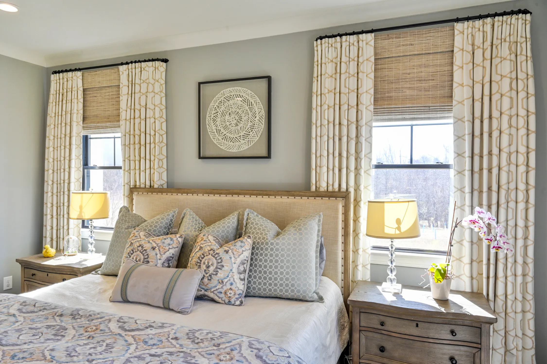 Layered custom drapery and window treatments in a comfortable bedroom