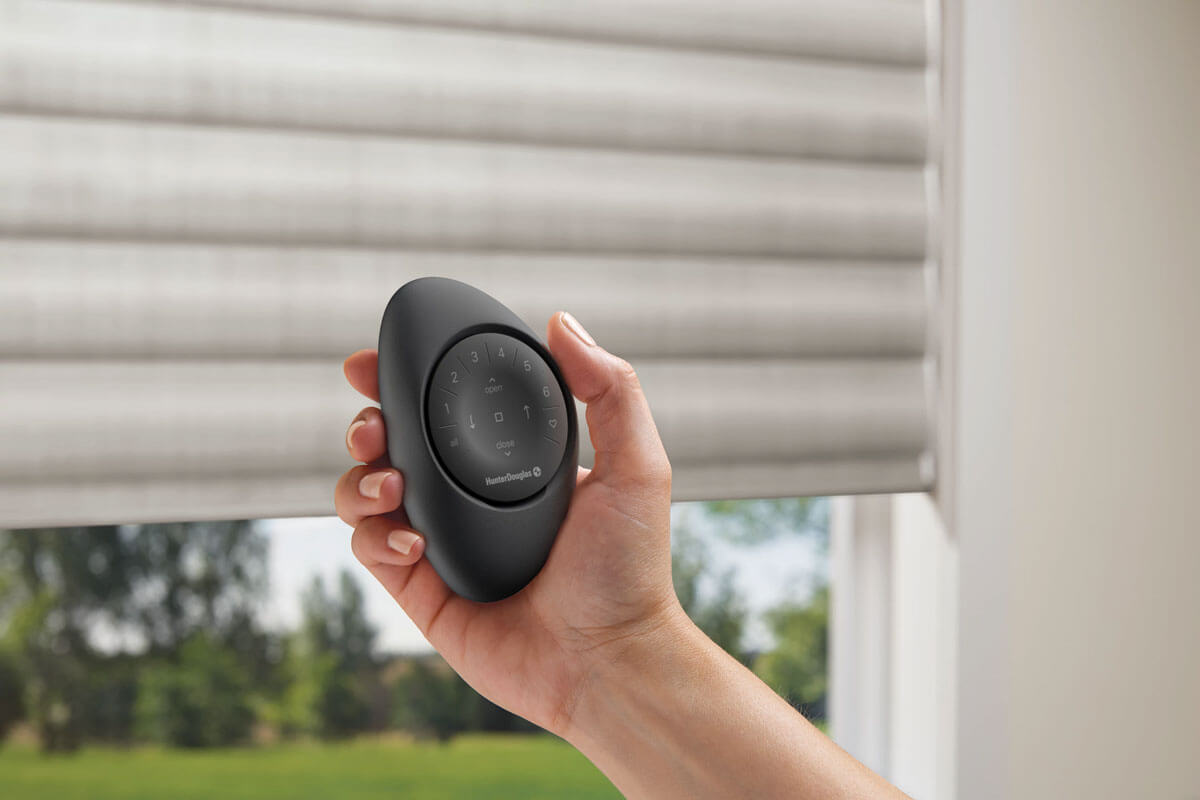 Hunter Douglas Pirouette window shades with a PowerView Pebble-style remote control shown in the room.