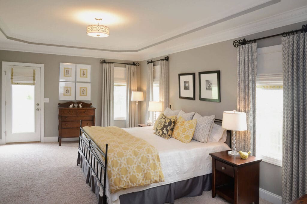 Layered Roman shades and custom drapery in a bedroom in Jamestown, NC.